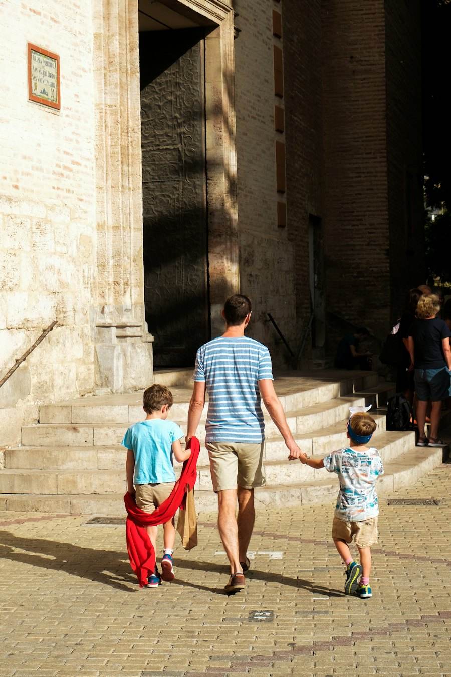 Father walking with his two children in a Spanish old town